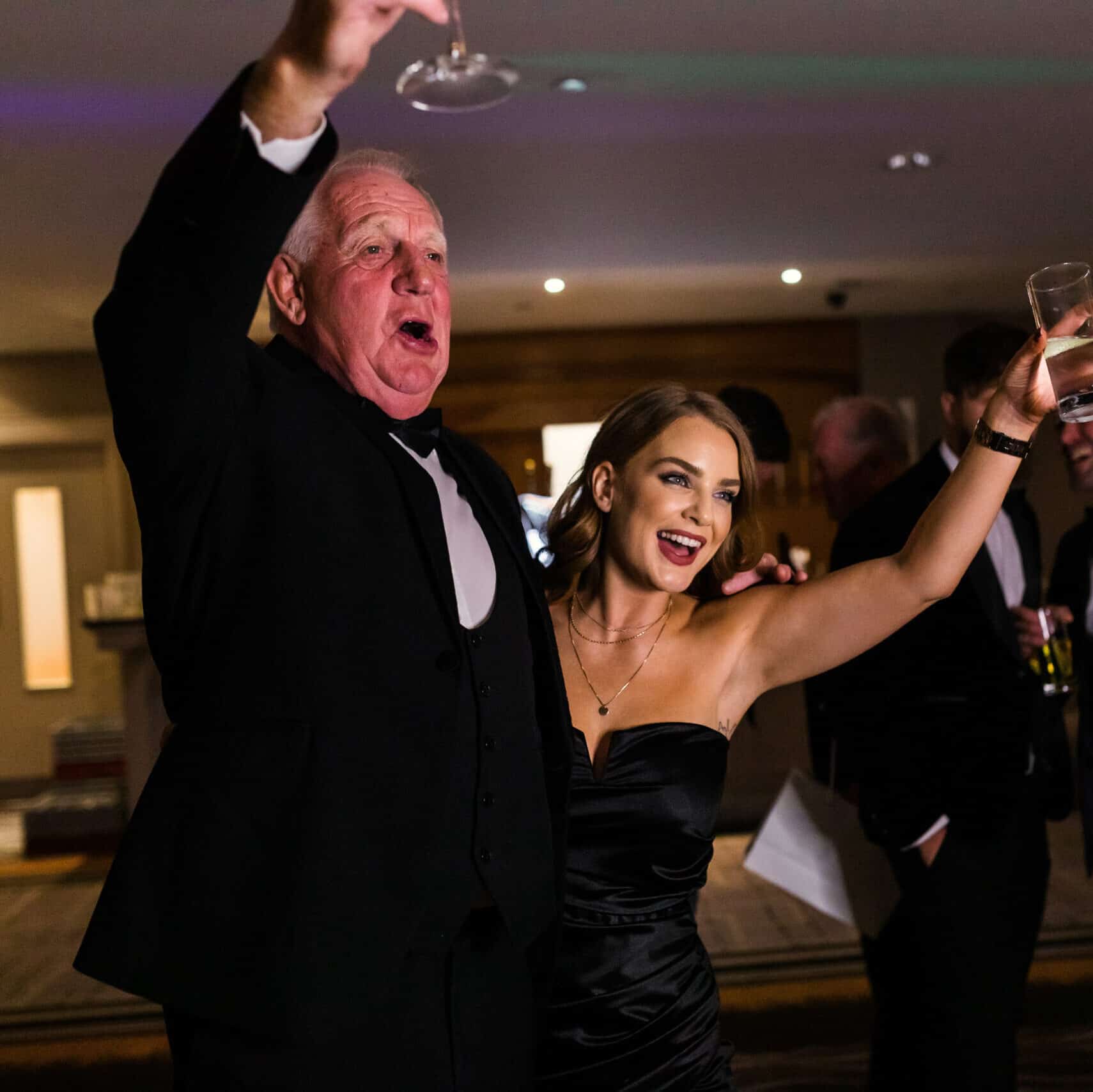 A group of people smiling and posing for a picture in a photo booth at an event, holding a large, custom-branded frame.
