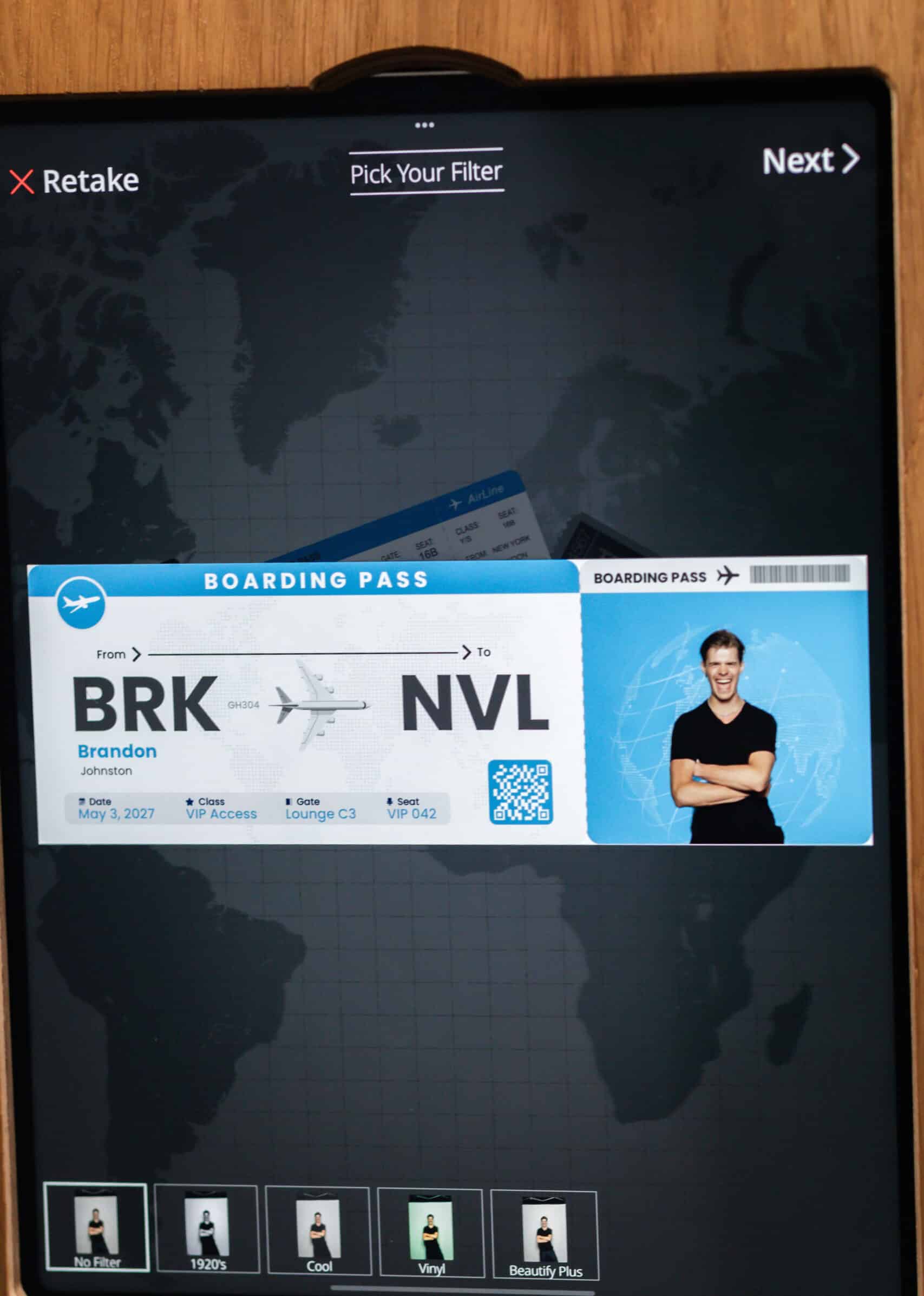 Two women in formal dresses smiling and posing for a picture in a photo booth at an event.