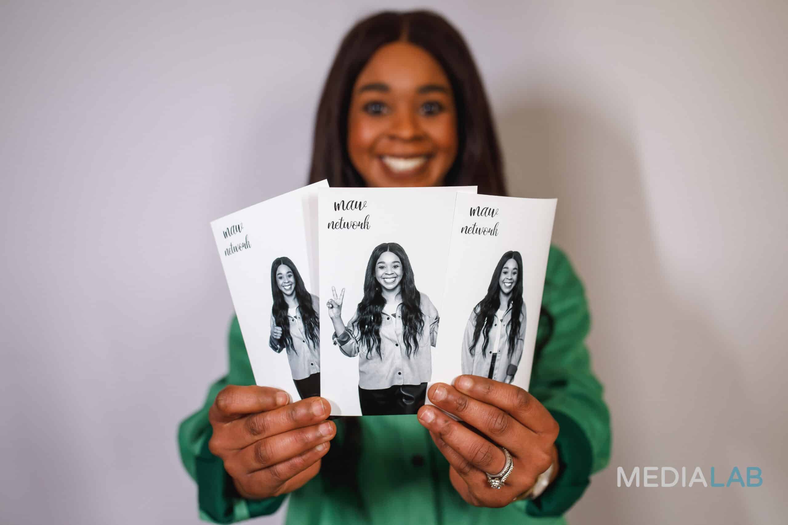 Two women in formal dresses smiling and posing for a picture at a corporate party.