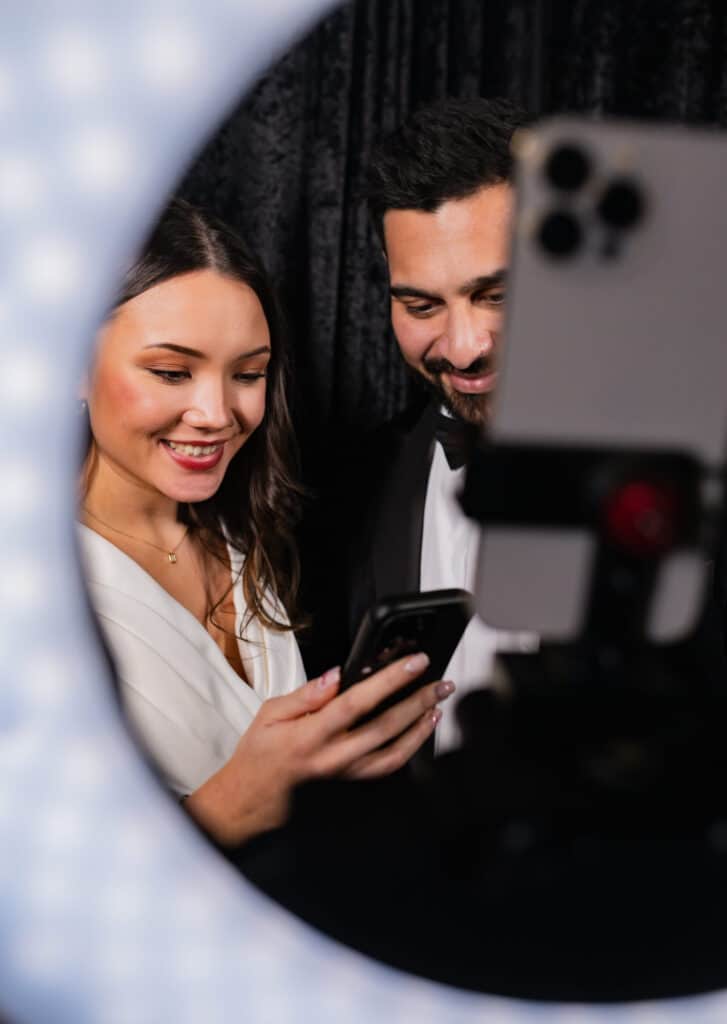 Two women smiling and posing for a picture in a photo booth at an event.