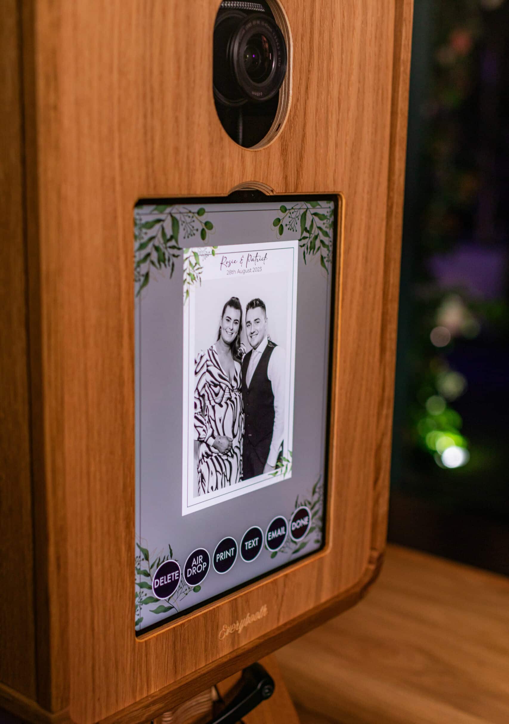 A group of people smiling and posing for a picture in a photo booth, holding various props including hats and a star-shaped sign.