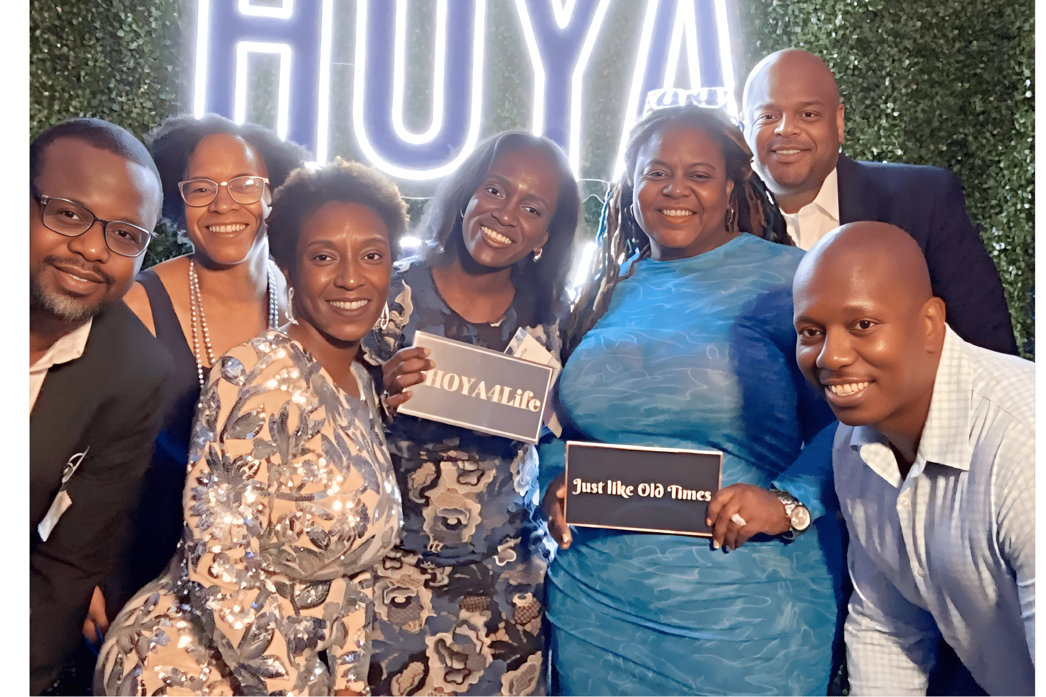 Two women smiling and posing for a picture at a convention, holding a large, branded frame.