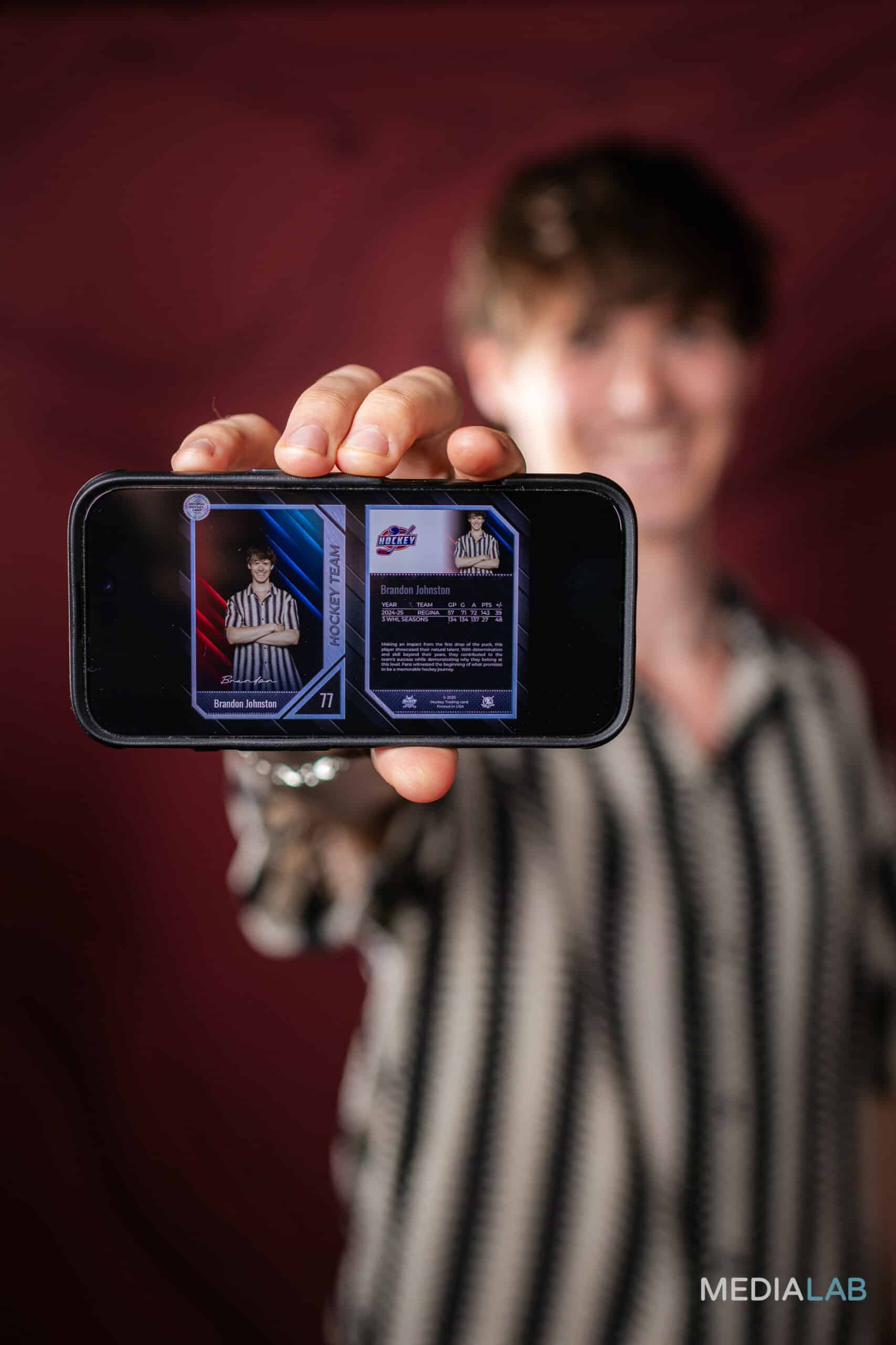 A guest holds a custom trading card created by a photo booth, featuring their own picture.