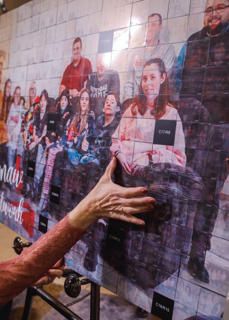 Guests interacting with a digital mosaic photo booth at a corporate party