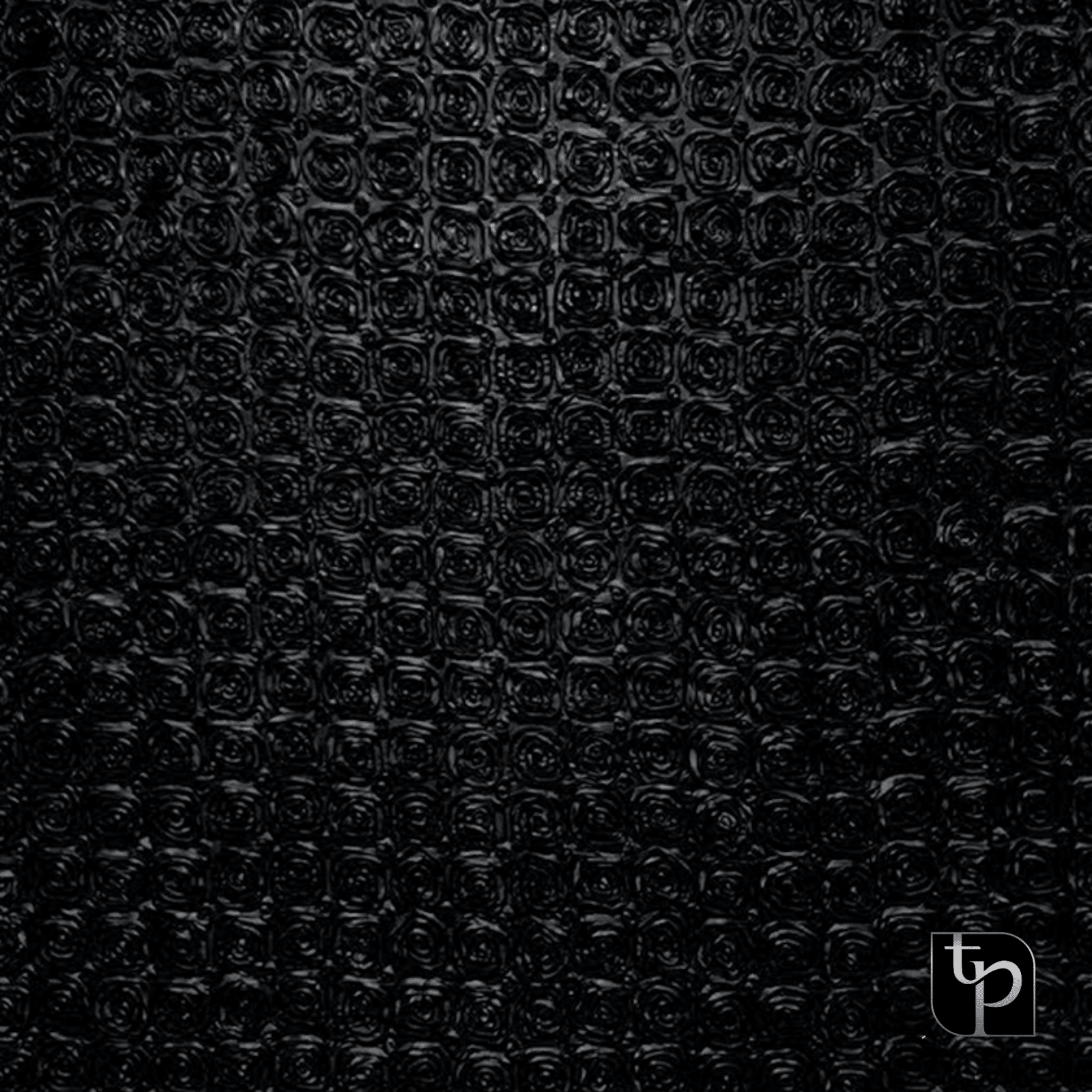 Black textured backdrop featuring a pattern of circular motifs, ideal for enhancing photography settings, with The Phototique logo in the corner.