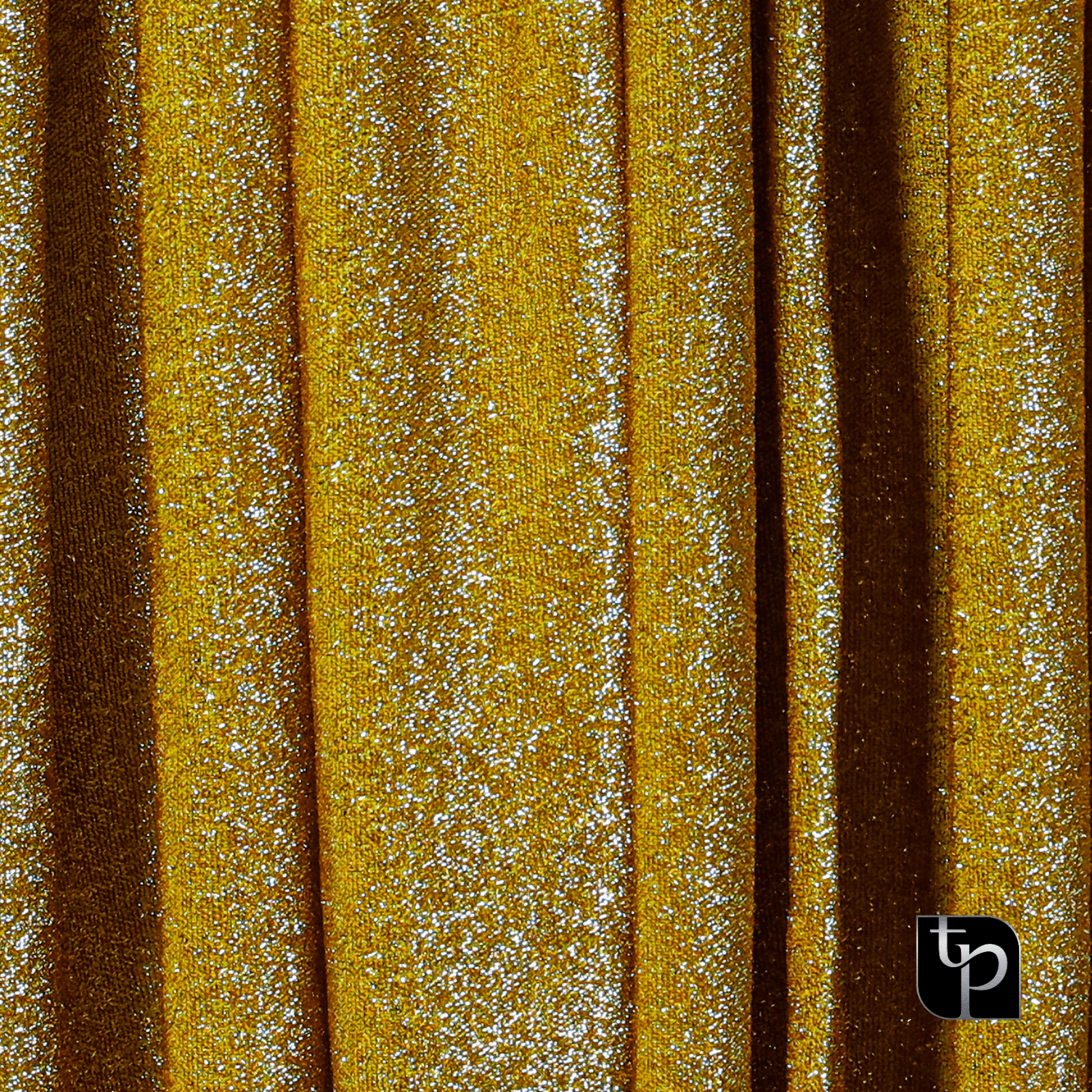 Glittering gold backdrop fabric with shimmering texture, ideal for enhancing photo shoot settings, featured by The Phototique.