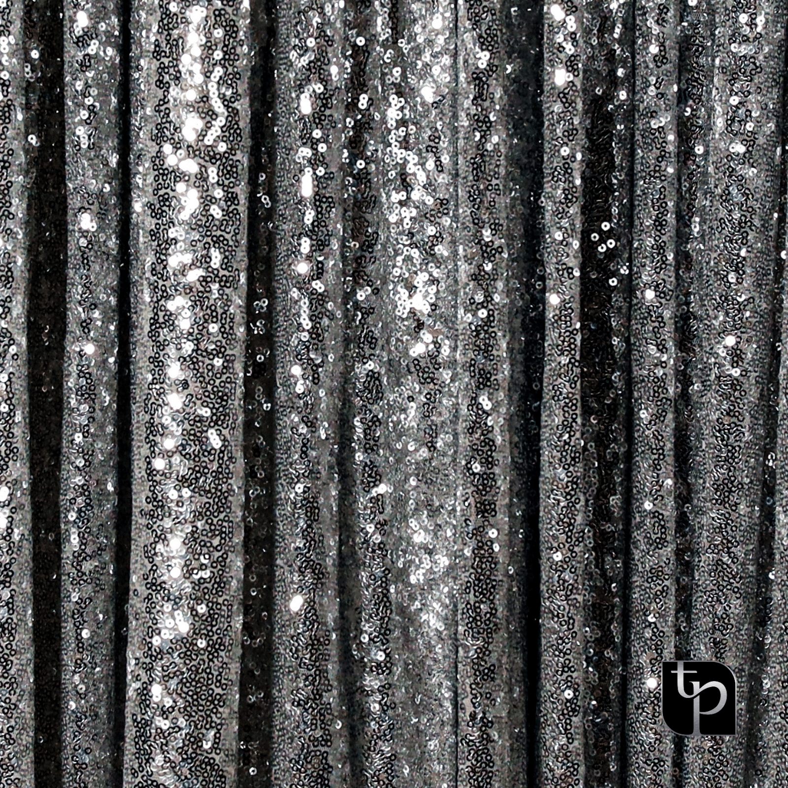 Silver sequin backdrop with shimmering texture, ideal for enhancing photography settings, featuring The Phototique logo.