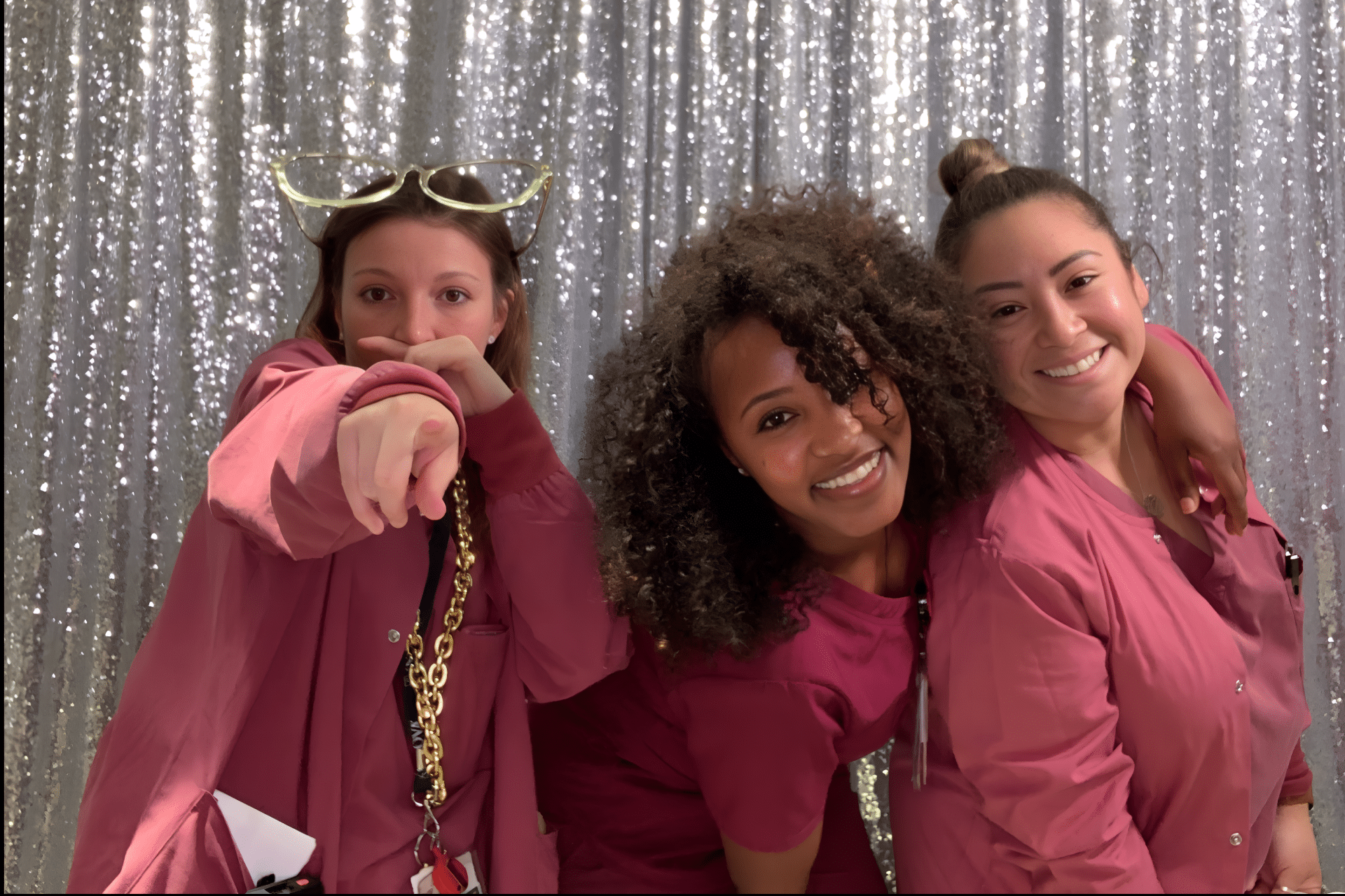 A woman in a surgical mask and scrubs smiling and posing for a picture at a Hospital Week appreciation event.