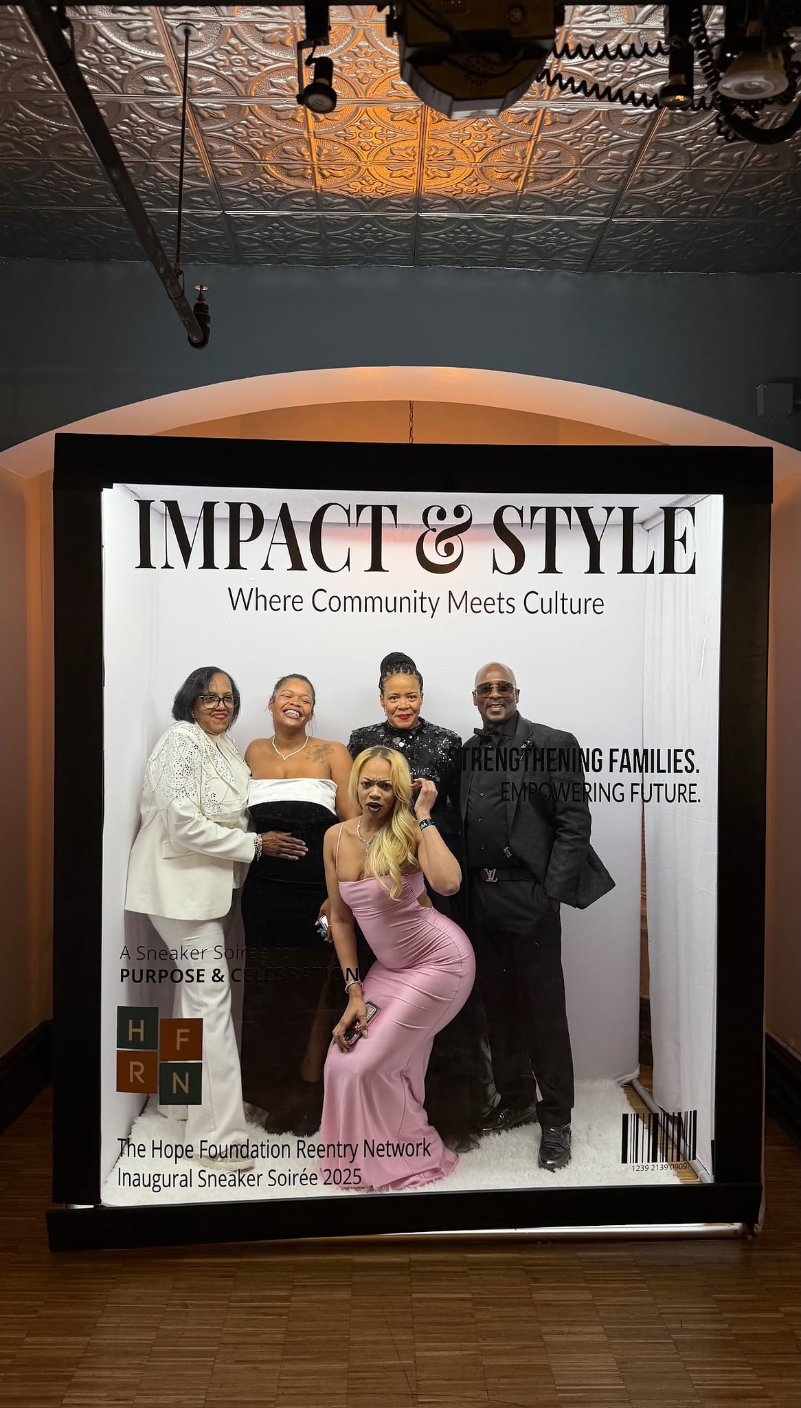 Group of five individuals posing in a photo booth with a backdrop reading "IMPACT & STYLE Where Community Meets Culture," showcasing an elegant event atmosphere for the Hope Foundation Reentry Network's Inaugural Sneaker Soirée 2025.
