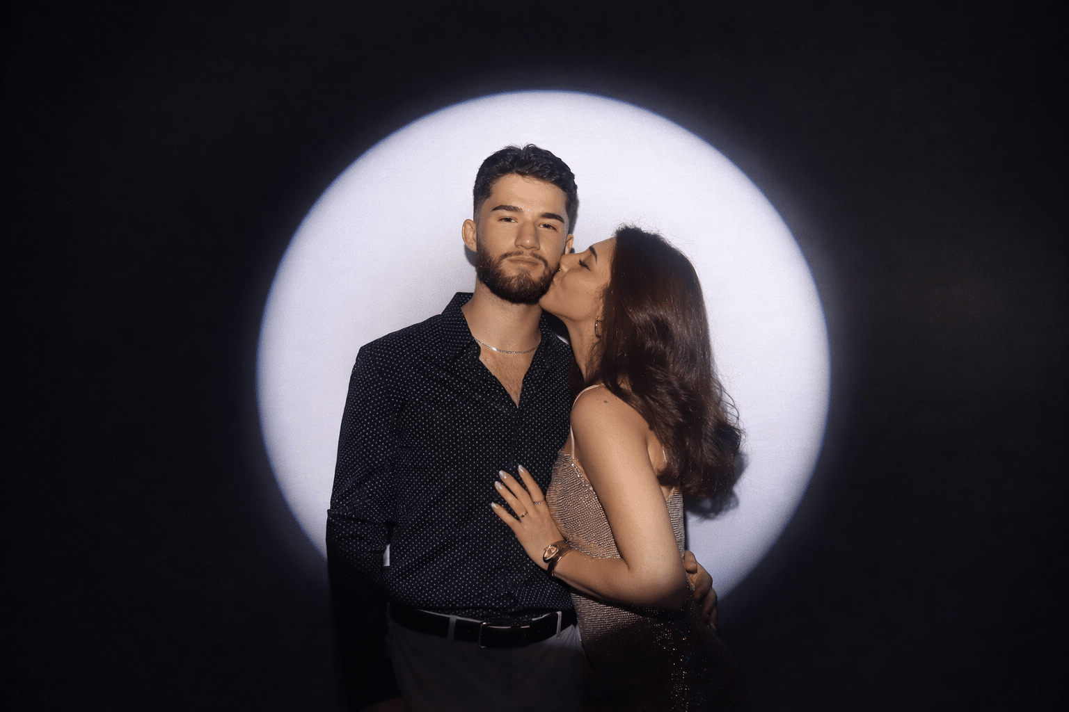 Couple posing in Spotlight Booth with dramatic lighting, showcasing editorial-style photography for premium event experiences.