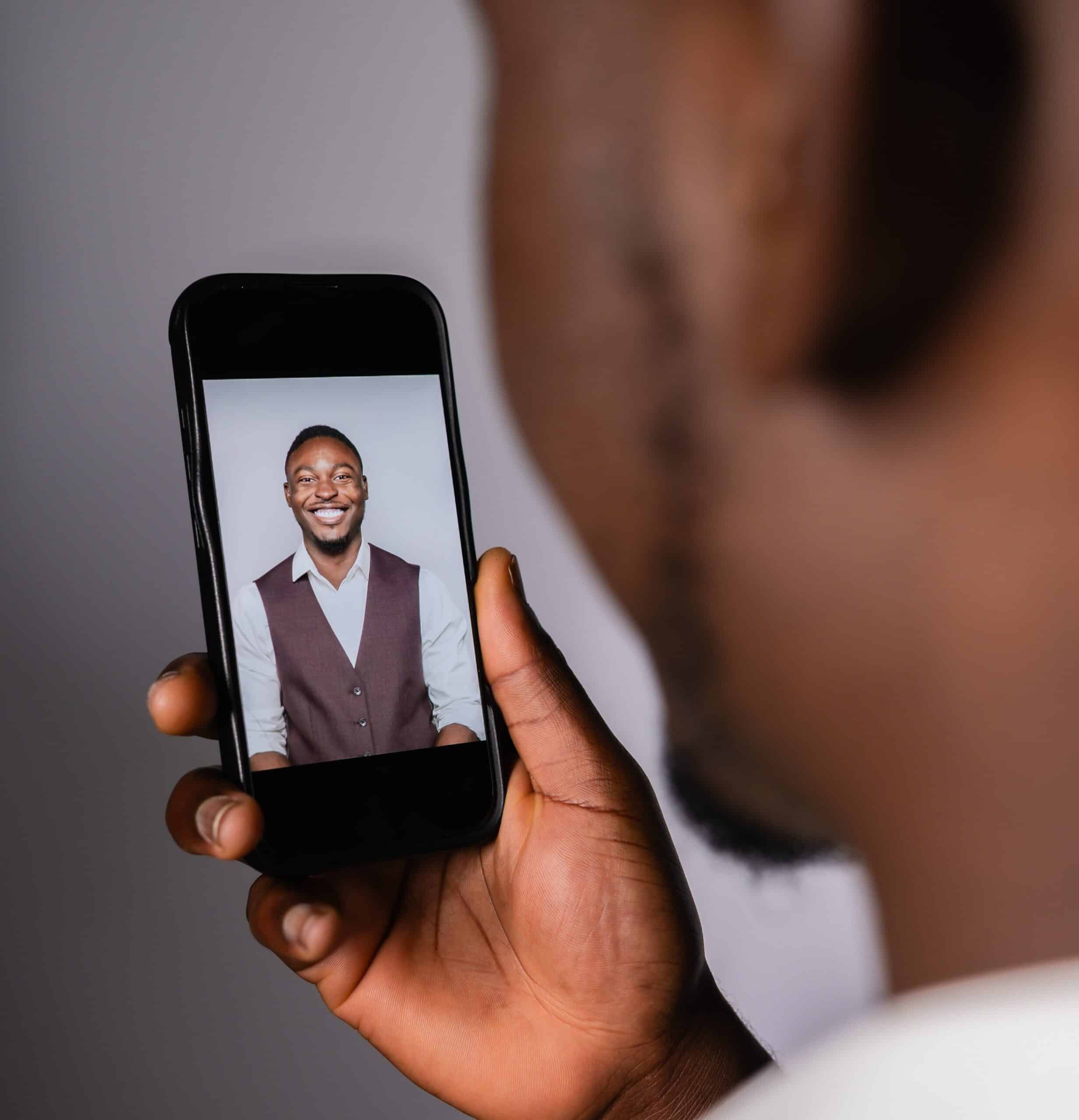 Person viewing a professional headshot on a smartphone, showcasing polished portrait photography suitable for corporate events and networking sessions.