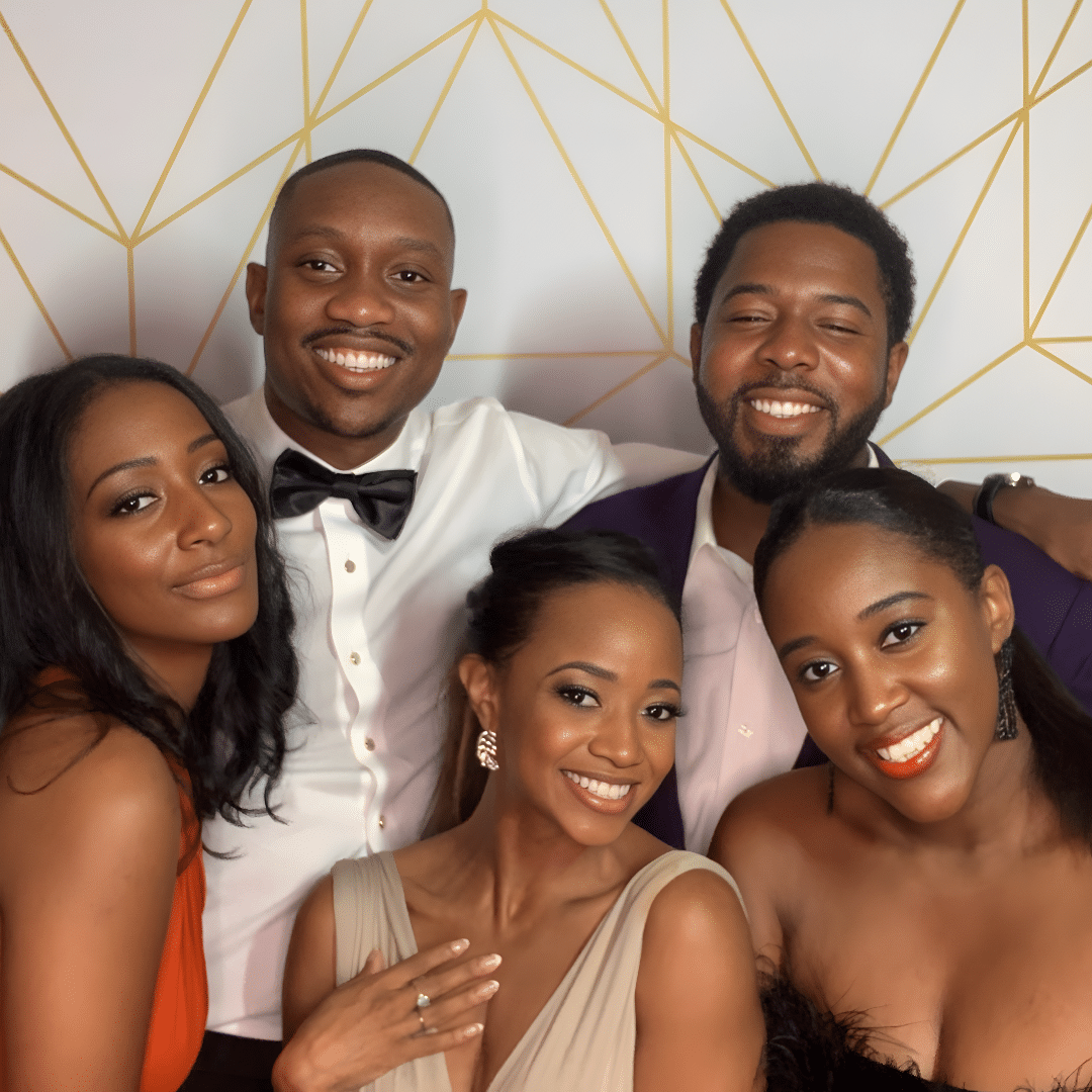 Group of five friends posing in a stylish photo booth with a geometric backdrop, showcasing joyful expressions and elegant attire, ideal for capturing memorable wedding moments.
