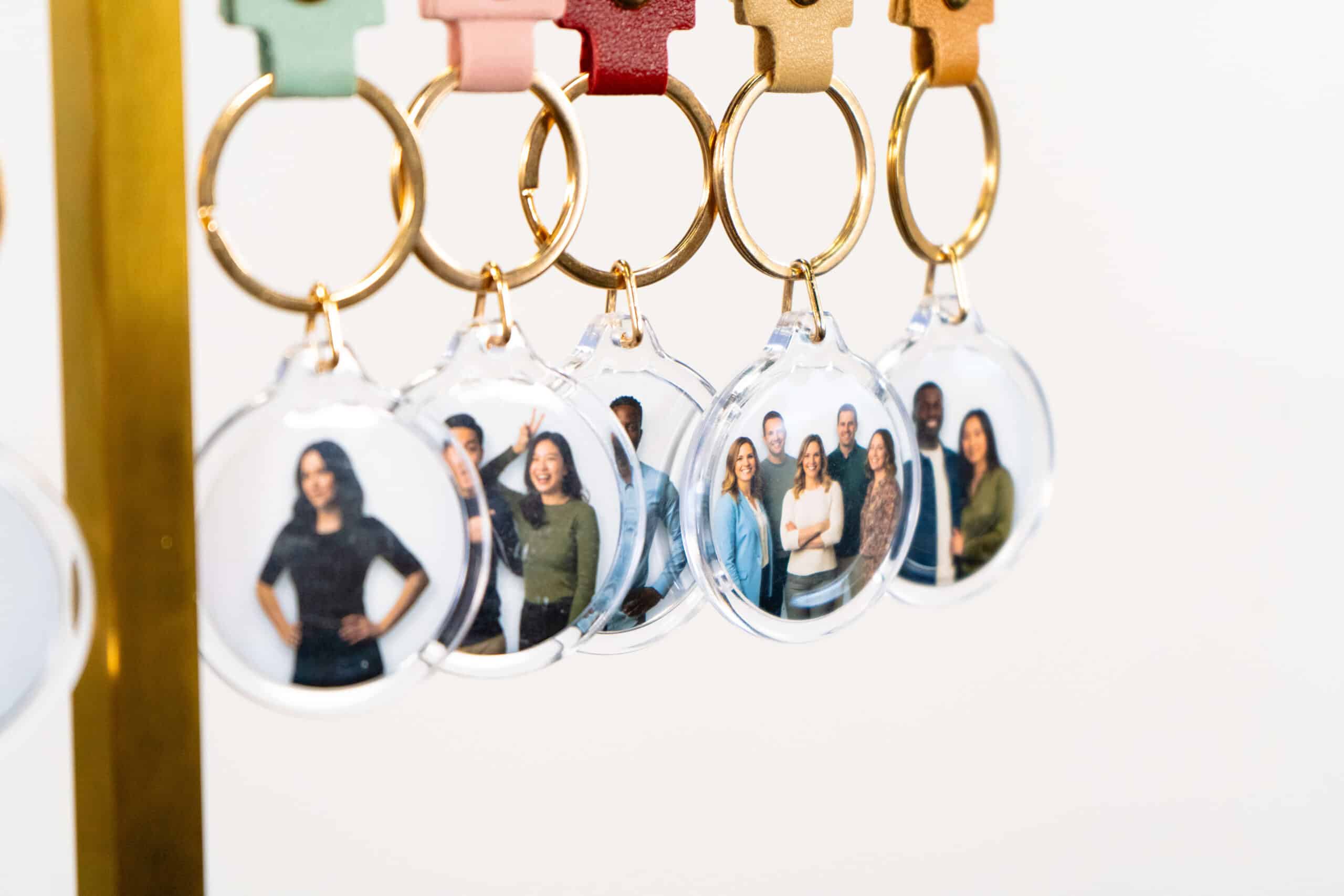 Keychains featuring personalized images of diverse individuals, showcasing customizable event merchandise from The Phototique's Merch Booth service.