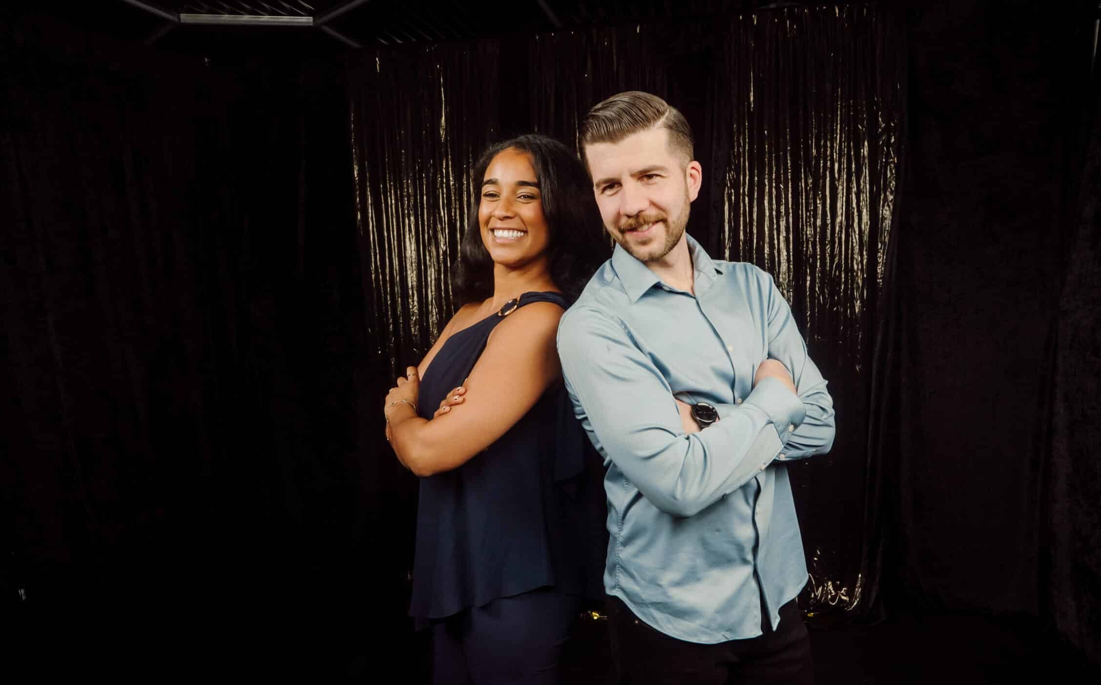 Smiling man and woman posing back-to-back in a stylish setting, showcasing GlamBot's red-carpet experience for events and celebrations.