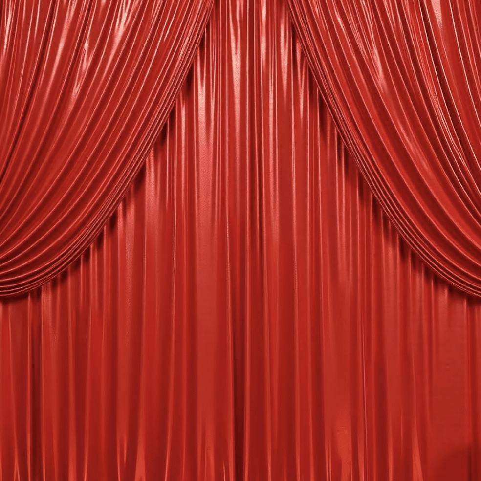 Red satin backdrop with elegant draping, ideal for enhancing photography settings at The Phototique.
