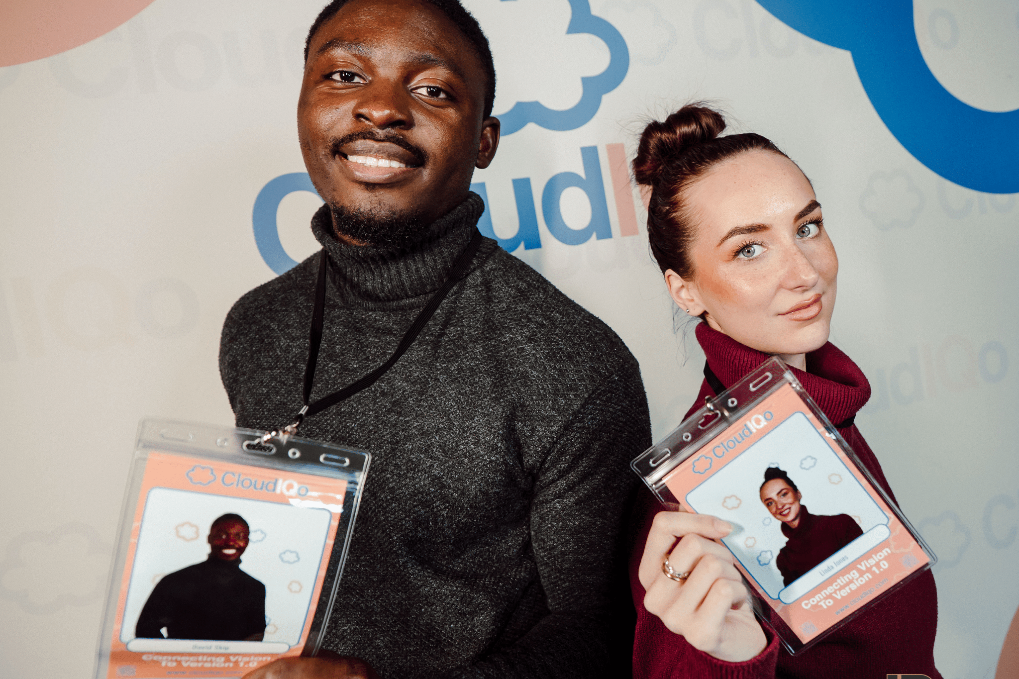 Two people show off their Lanyards from photo booth