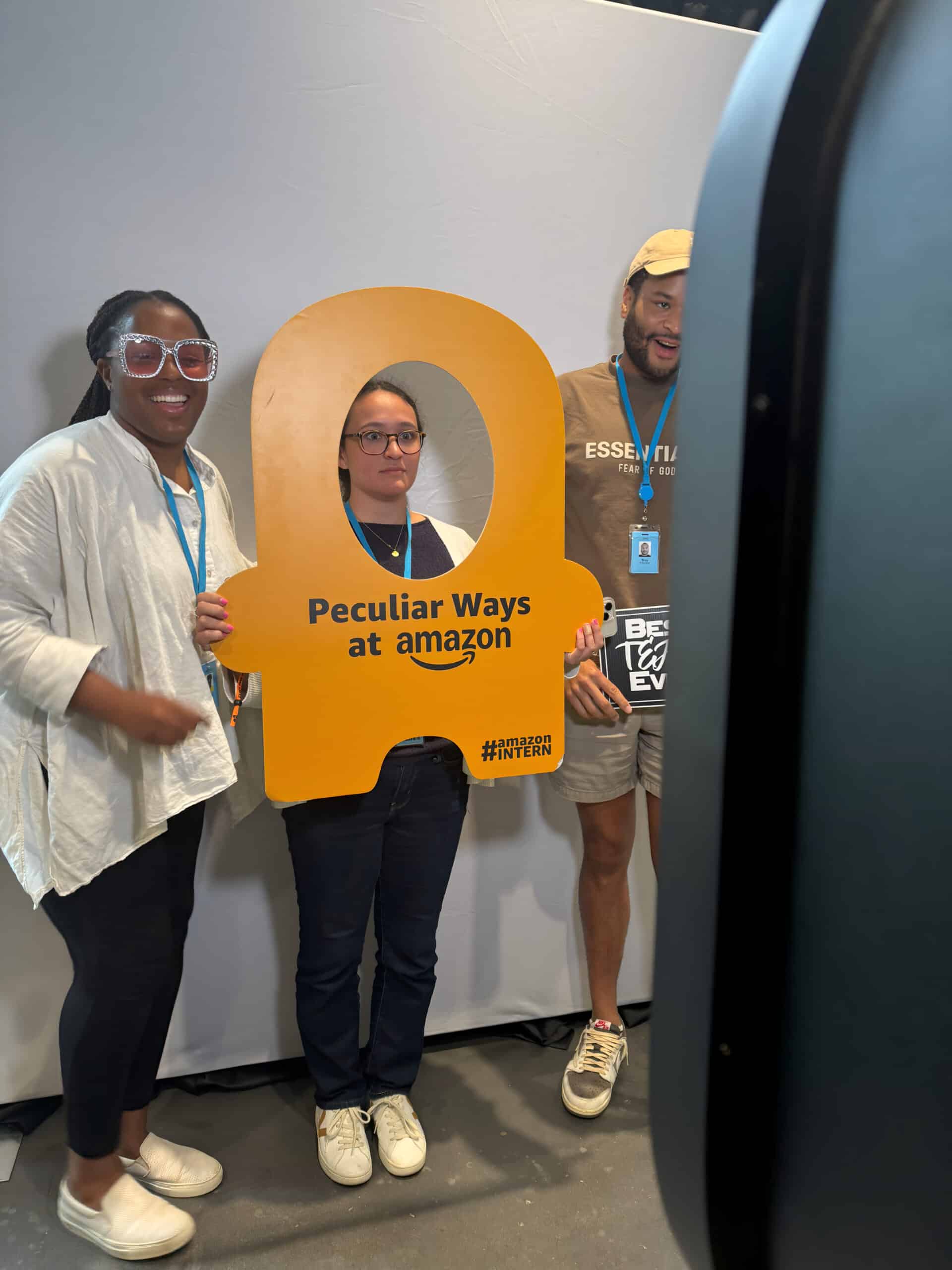 Amazon employees posing front of the backdrop