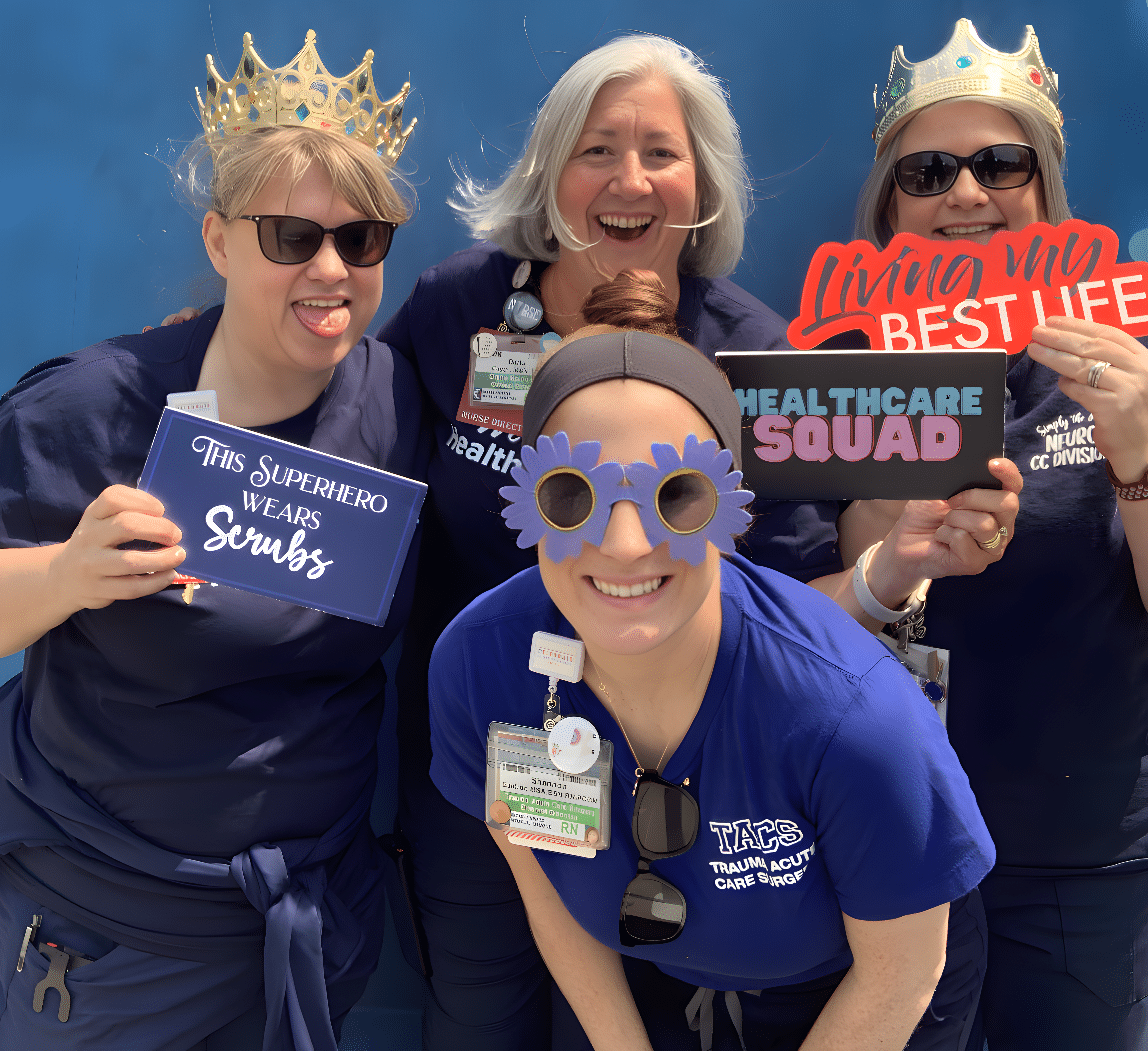 health care professional posing for a photo booth with prop signs and glasses during health care week