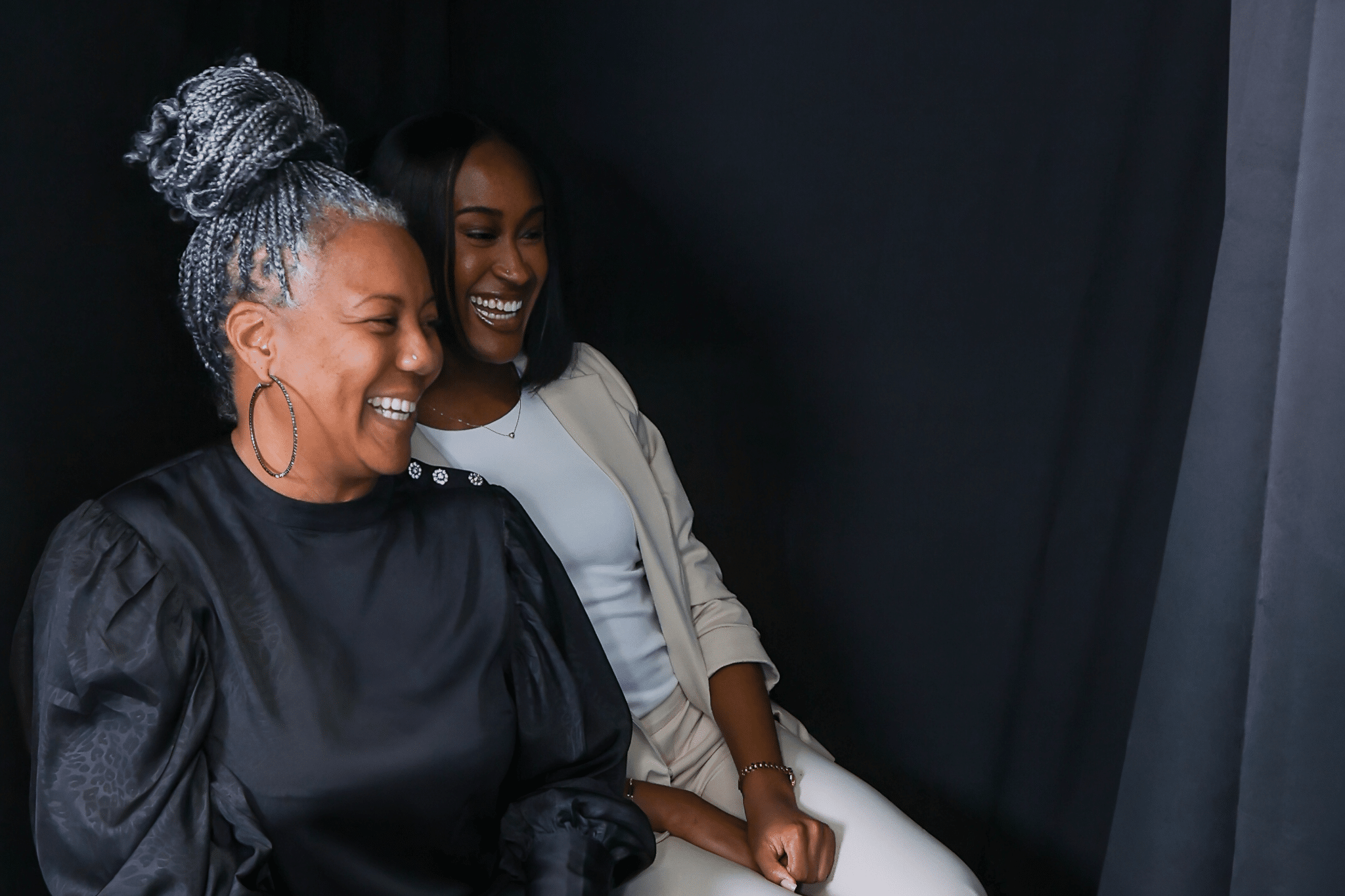 Two women sitting in an eclosed photo botoh for a brand activation in washington, DC