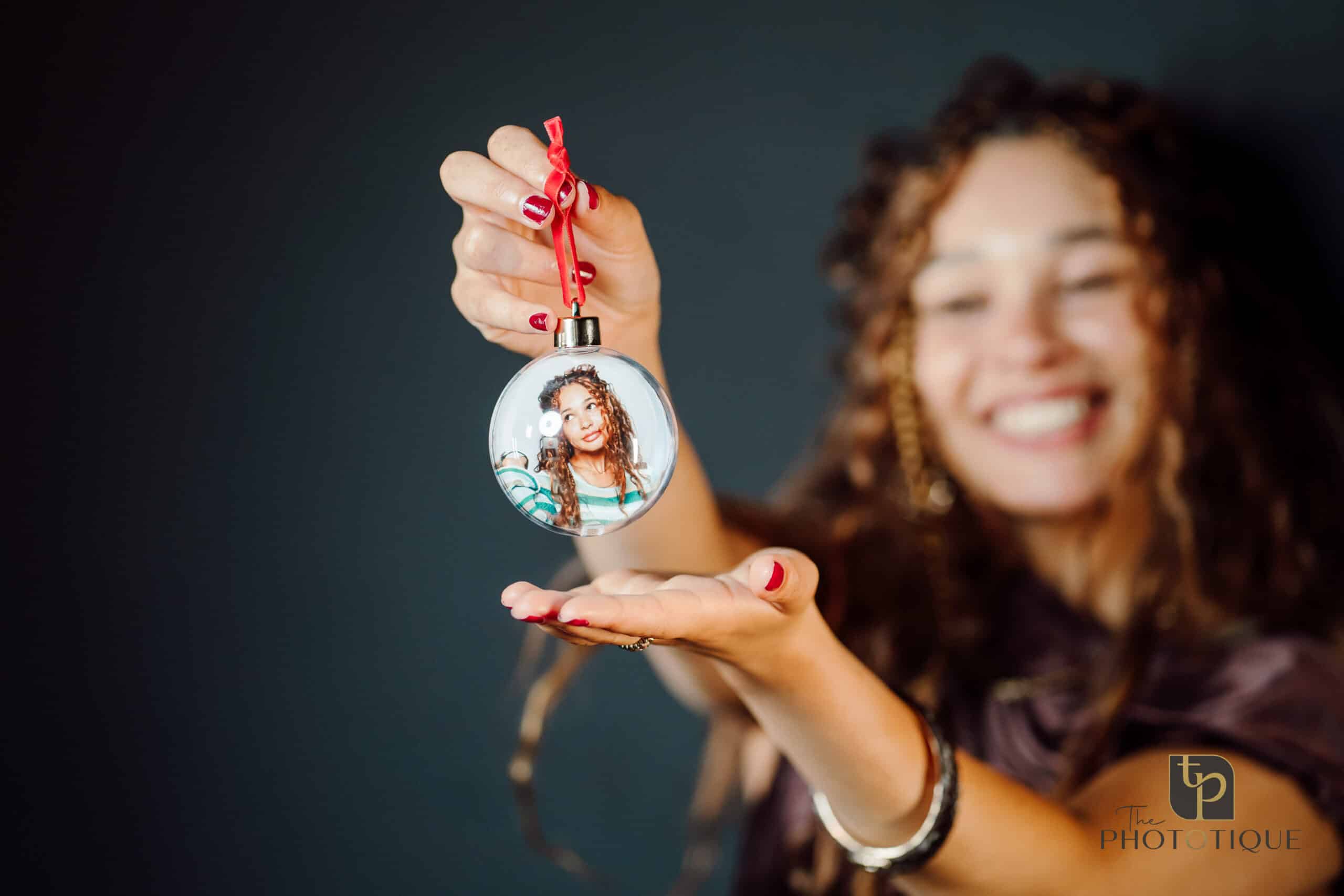 Woman shows her custom holiday ornament made in the photo booth