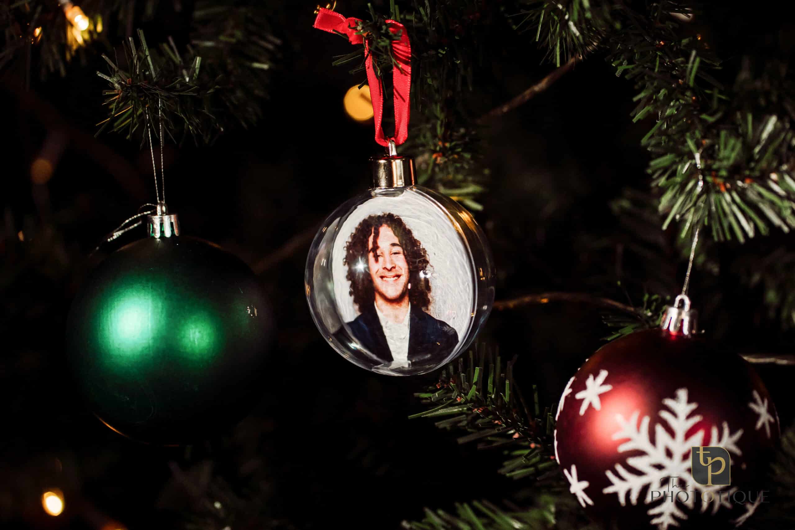 custom photo booth holiday photo ornament hanging on a tree.