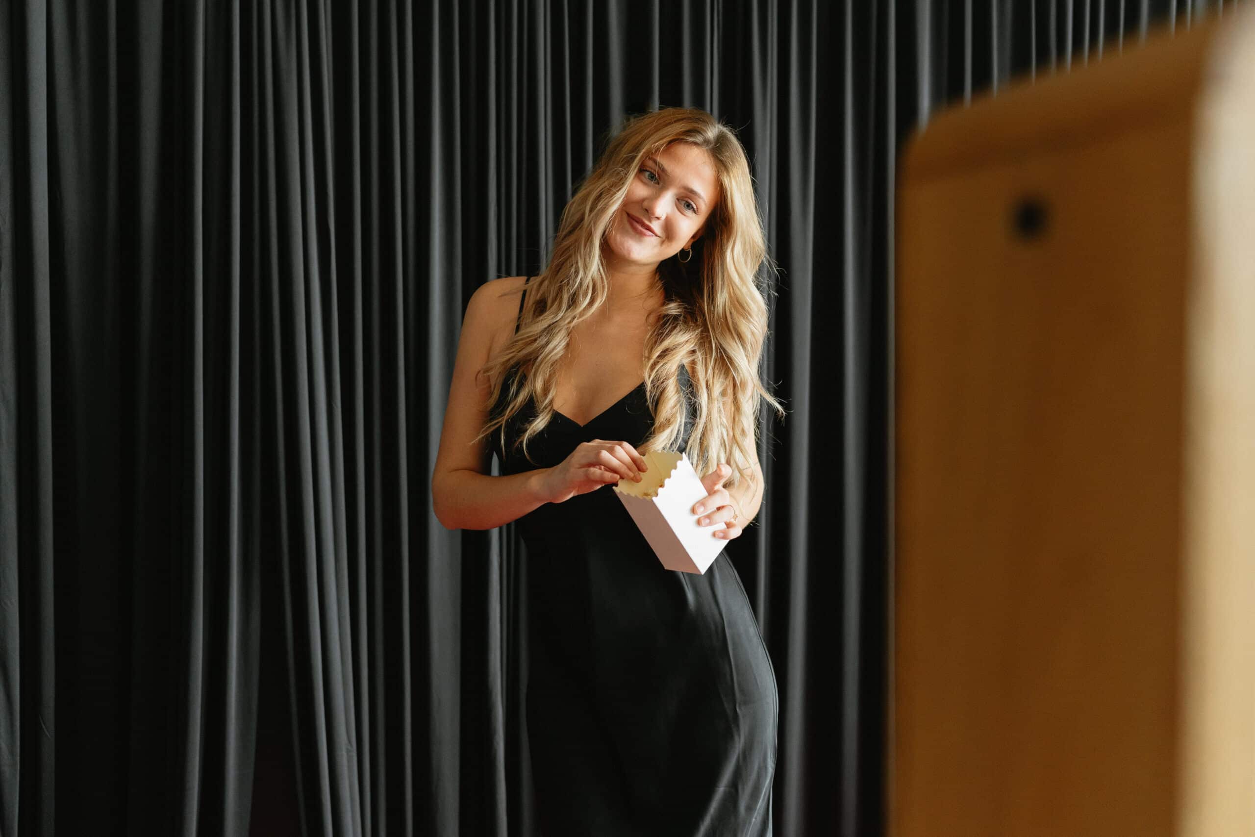 a woman with blonde hair and a gala dress, stands in front of the photo booth and poses at a gala in washington, dc