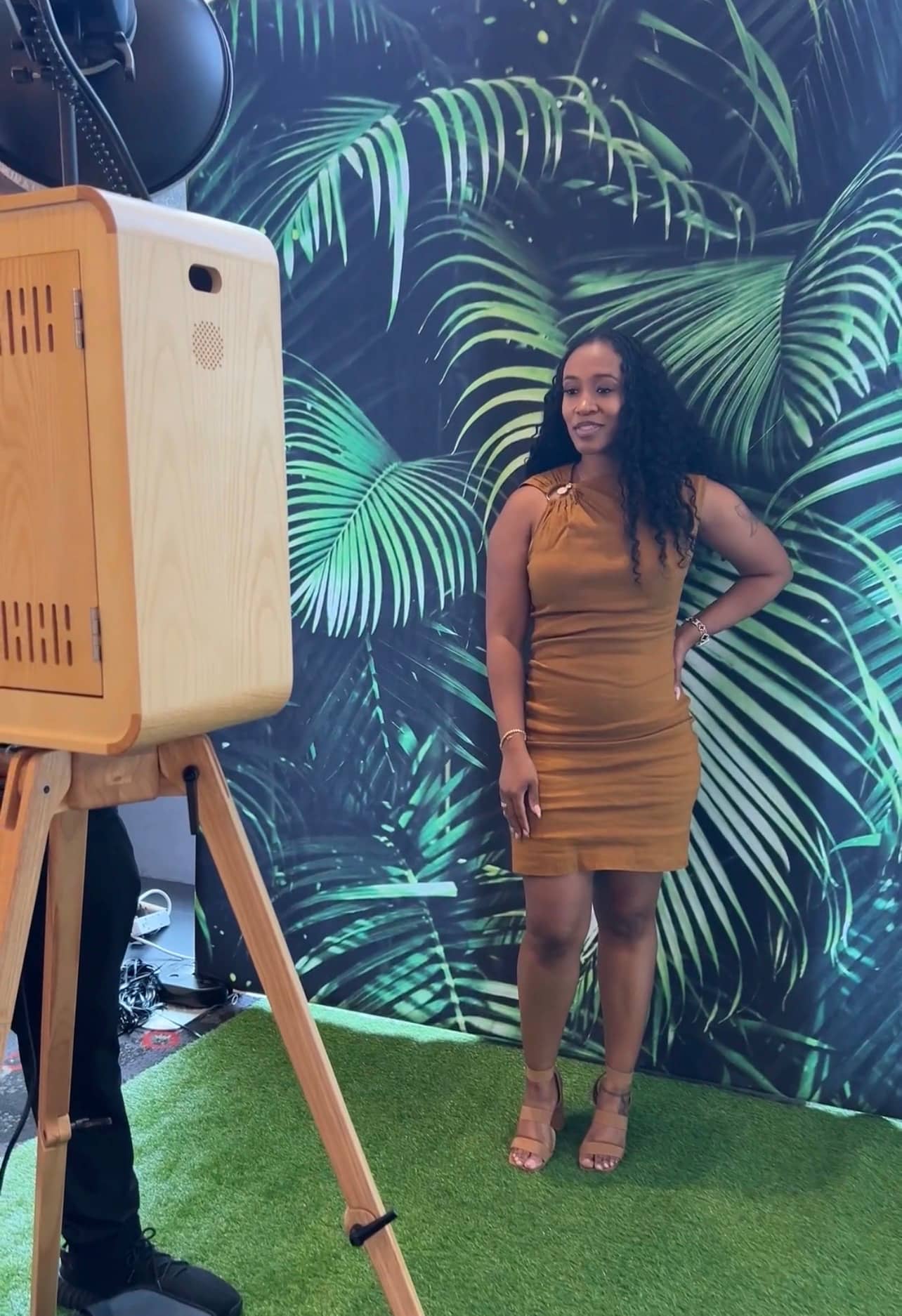 Woman stands in front of a palm leaf backdrop and poses for the photo in dc